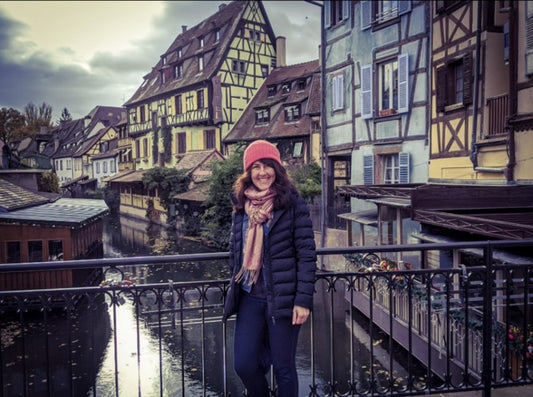 Girl standing in front of colorful buildings in Colmar France